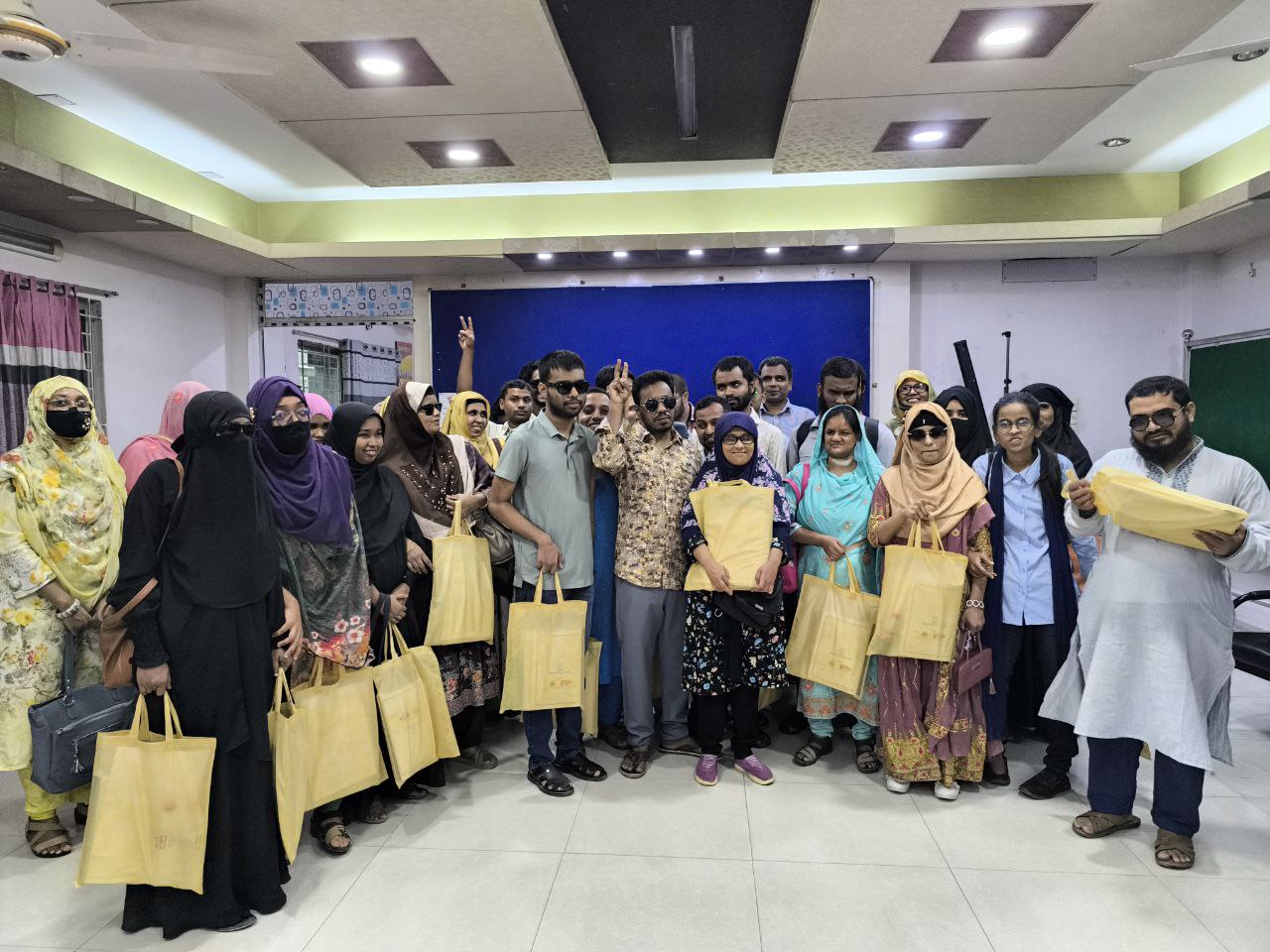 Visually impaired participants from in-person capacity-building training on advocacy skills, leadership skills, effective communication, gender & safeguarding issues, disability laws, and the Cyber Security Act for OPDs leaders and VIPS members & college and university-level students with disabilities are standing by holding Braille government circulars, books distributed by VIPS